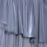 Close-up of the KIKI and JOJO Girls Velvet Asymmetrical Hem Puff Sleeve Dress in gray, featuring a sheer layered tulle skirt and a bodice with white jacquard embroidery and floral patterns.