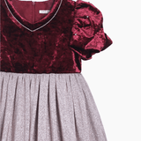 The KIKI and JOJO Girls Velvet Puff Sleeve Dress in burgundy red features rhinestone trim, a short puffed sleeve, and a shimmery silver pleated skirt—perfect for special occasions.
