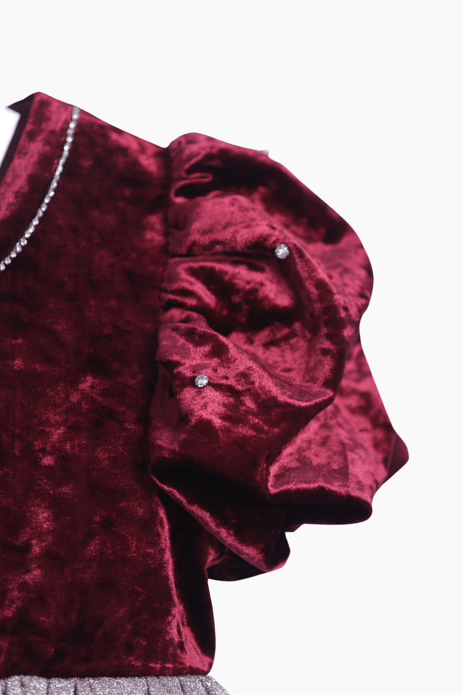 Close-up of the KIKI and JOJO Girls Velvet Puff Sleeve Dress in burgundy red, featuring rhinestone trim—an elegant choice for special occasions—shown against a white background.