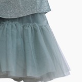 Close-up of a layered skirt with a shiny metallic top and sheer blue-gray tulle bottom—ideal for pairing with the KIKI and JOJO Girls Velvet Puff Sleeve Dress with Rhinestone Trim in Forest Green for special occasions.