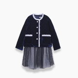 The KIKI and JOJO Girls Velvet & Tulle Dress in Sapphire Blue features a quilted navy bodice with white trim, button details, and a matching tulle skirt with a gray mesh underlayer—perfect for special occasions. Displayed on a white background.
