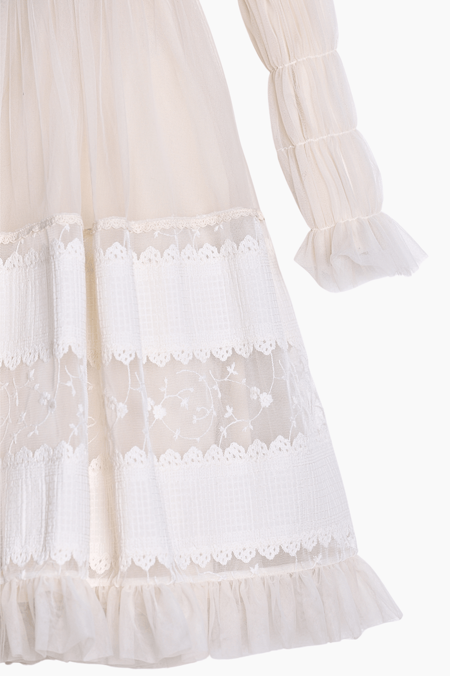 Close-up of the Girls Vintage Pearl Embroidered Tulle Dress in beige by KIKI and JOJO, featuring sheer long sleeves, a delicately embroidered bodice with floral details, lace panels, and a ruffled hem.