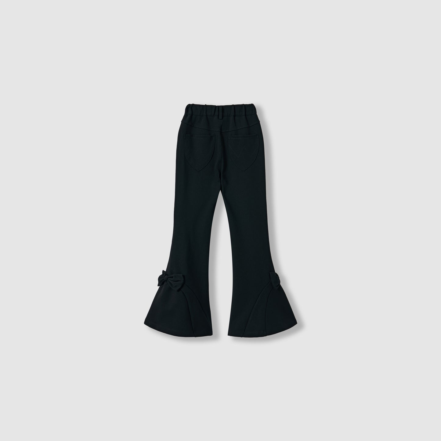 The Petal Whisper Dress Pants by KIKI and JOJO feature a black flared silhouette, elastic waistband, back pockets, and bow details at the hem. Made from stretchy fabric, they're shown against a plain light background.