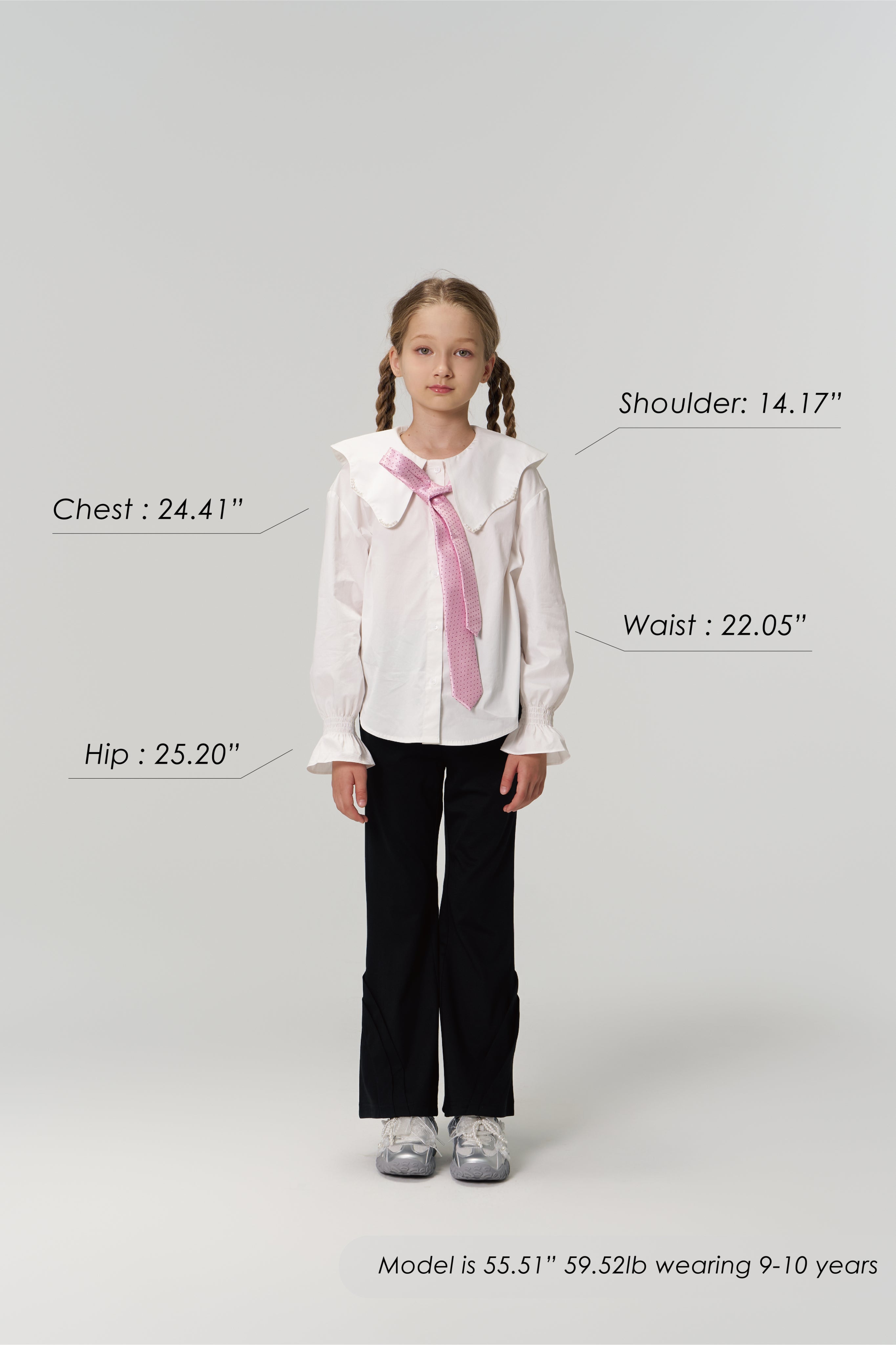 A young girl models KIKI and JOJO Echo Whisper Dress Pants, standing forward in a white blouse with a pink tie. Chest, hip, waist, and shoulder measurements are shown beside her height and weight for size reference.