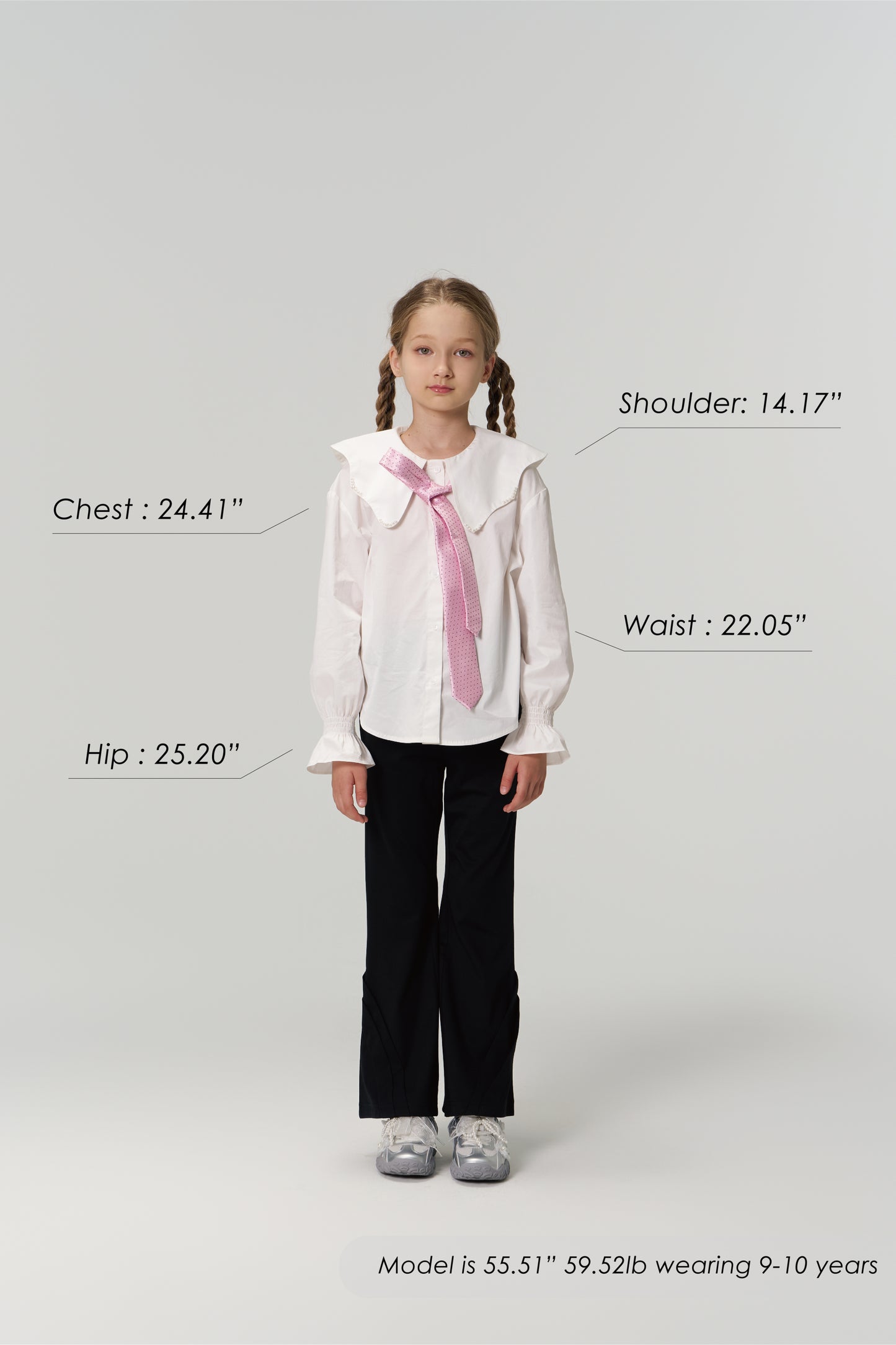 A young girl models KIKI and JOJO Echo Whisper Dress Pants, standing forward in a white blouse with a pink tie. Chest, hip, waist, and shoulder measurements are shown beside her height and weight for size reference.
